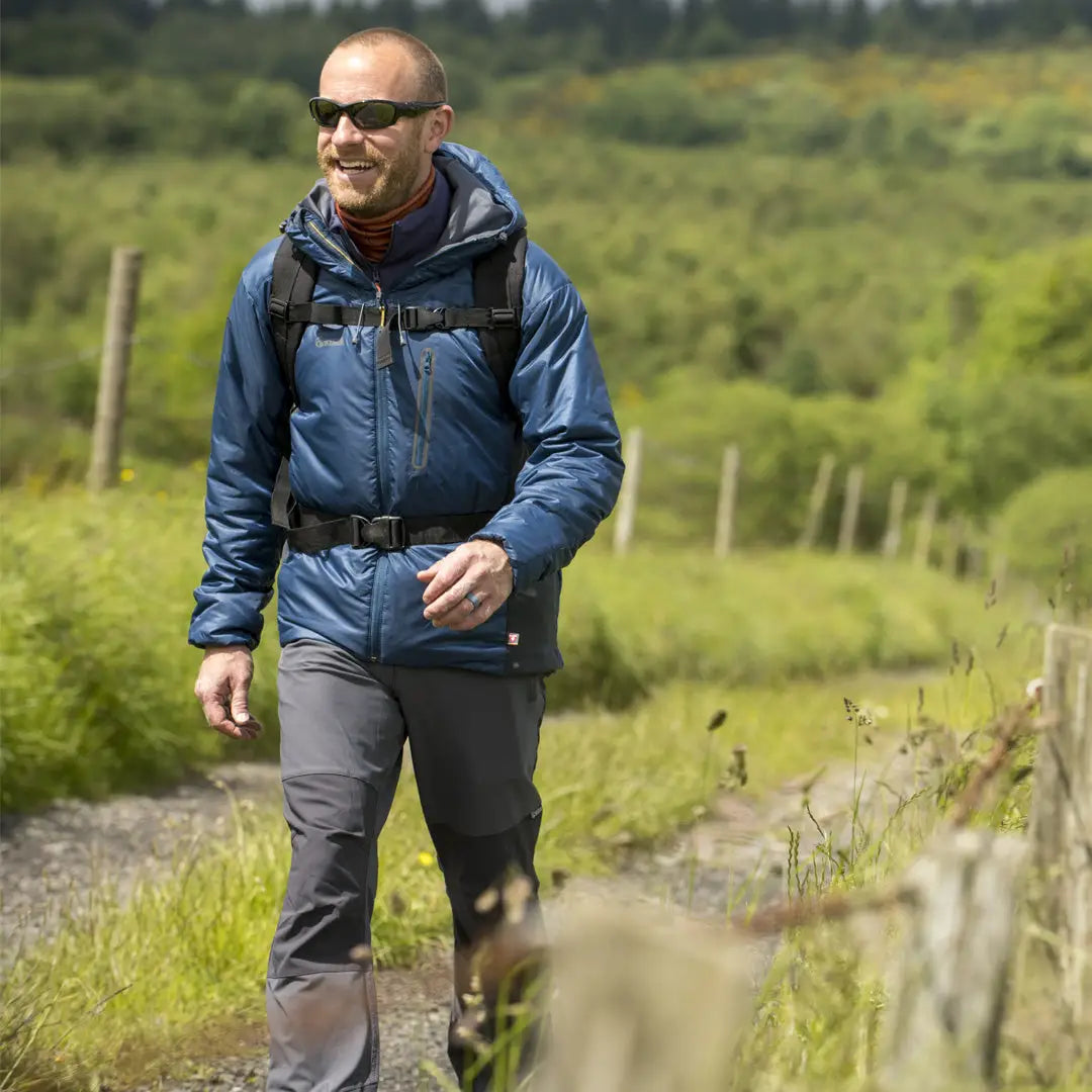 Man in a blue jacket and sunglasses enjoying nature in a Keela Talus Primaloft Jacket