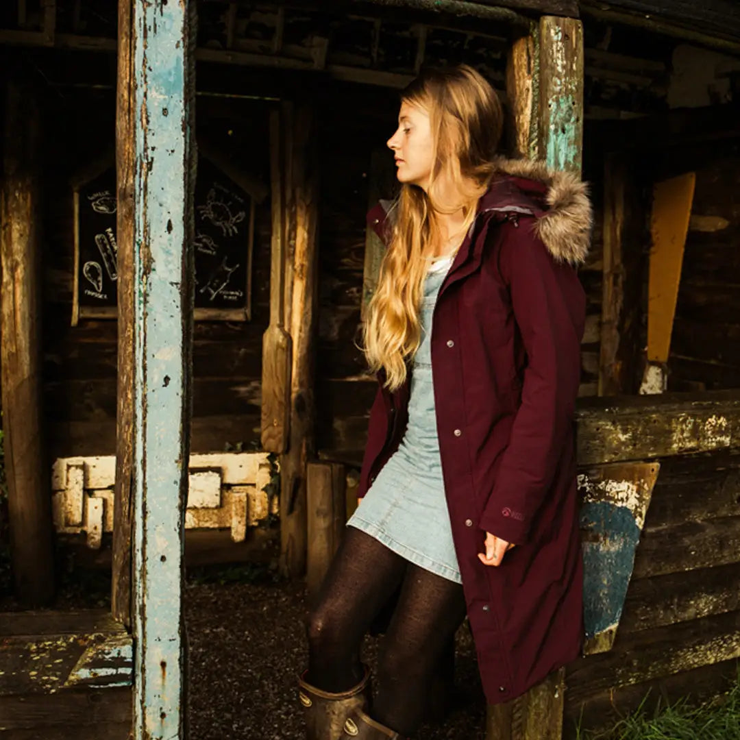 Woman in a burgundy fur-trimmed hooded coat perfect for country clothing and outdoor adventures