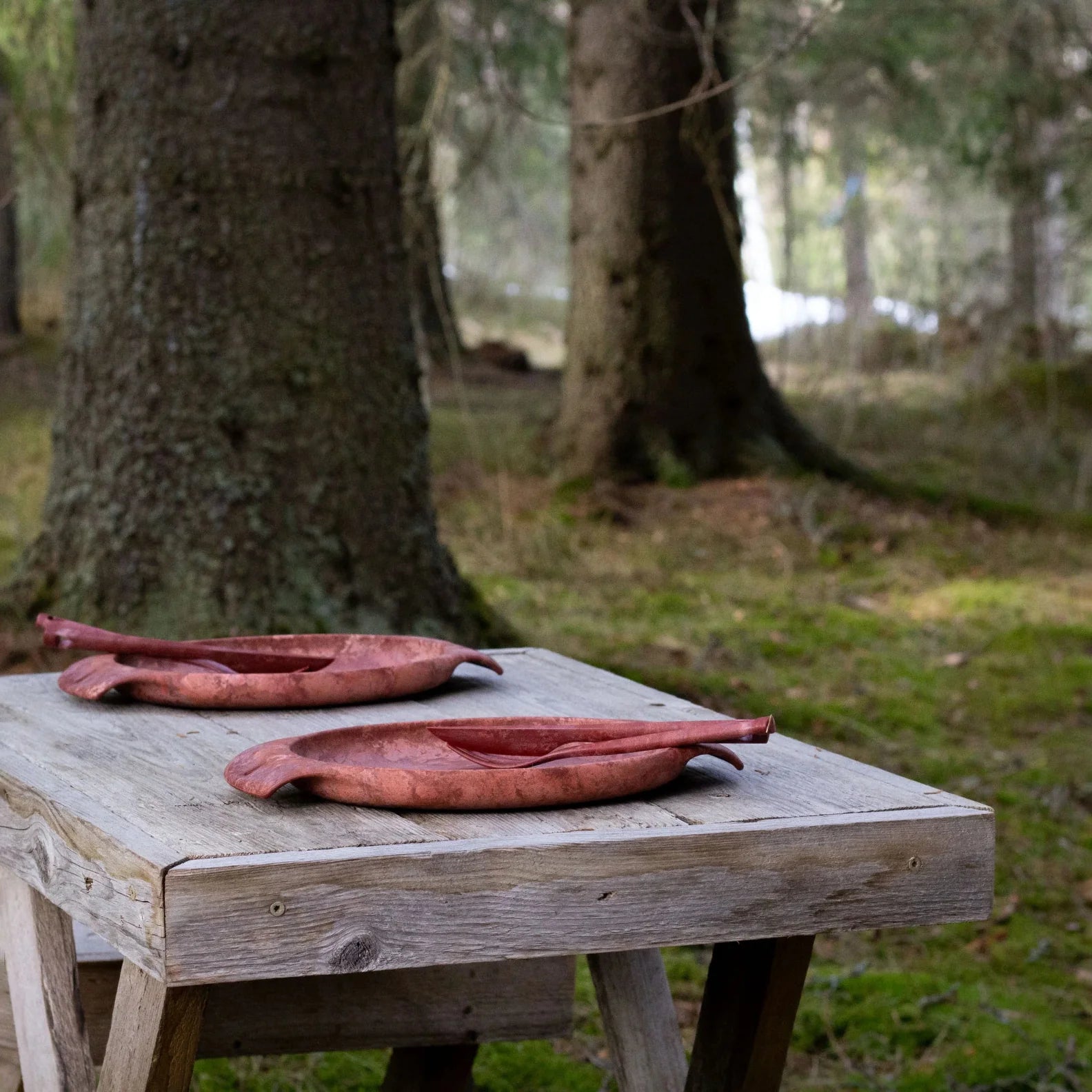 Two rustic reddish-brown wooden bowls from the Kupilka Fill That Belly Gift Set