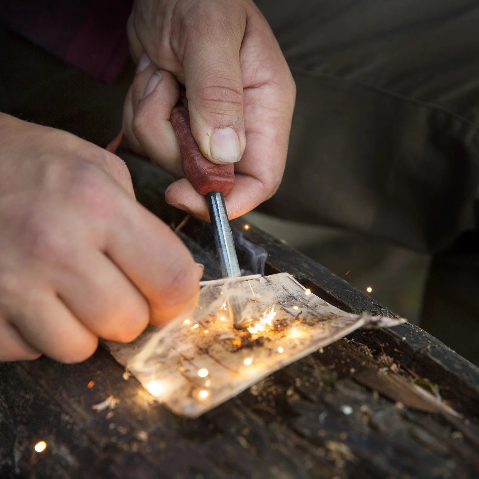 Fire starter in use with Kupilka Firesteel to create sparks with a compact striker