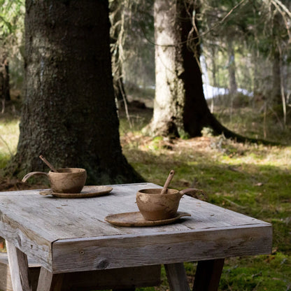 Rustic wooden cups and saucers in the Kupilka Slow Down Gift Set, perfect for cozy vibes