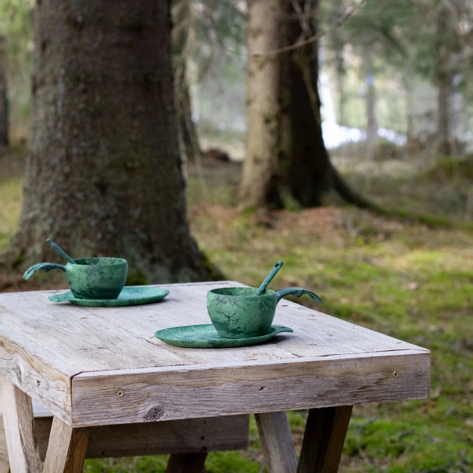 Two green ceramic teacups with spoons from the Kupilka Slow Down Gift Set