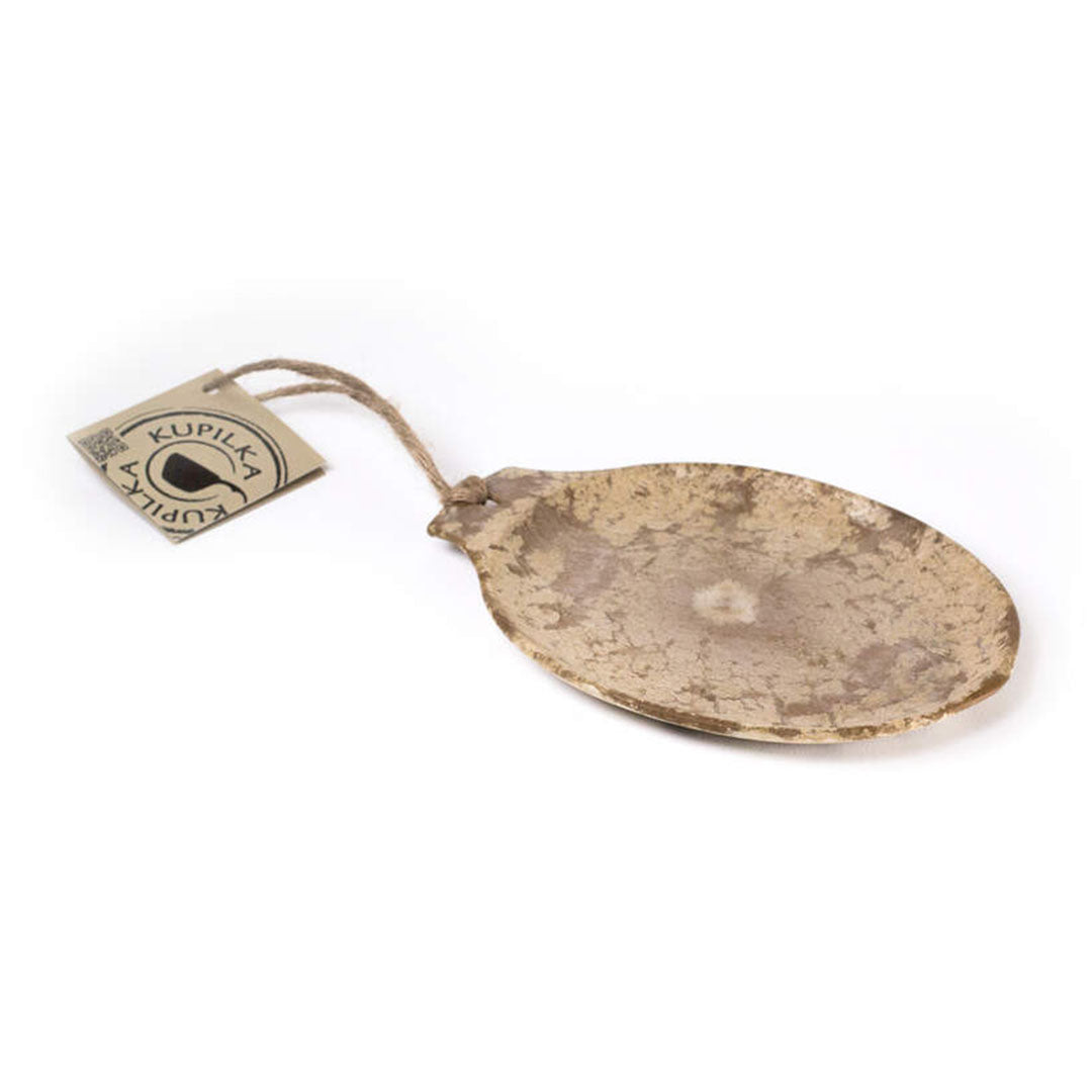 Oval beige textured spoon with a tag next to a Kupilka Small Plate 140ml