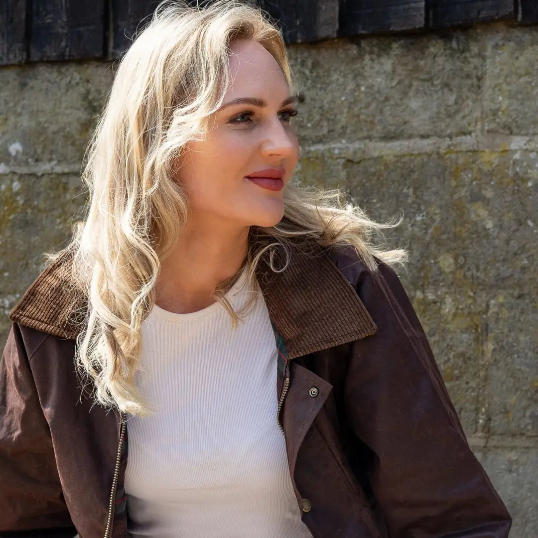 Woman with long blonde hair in a brown Antique Wax Jacket over a white top