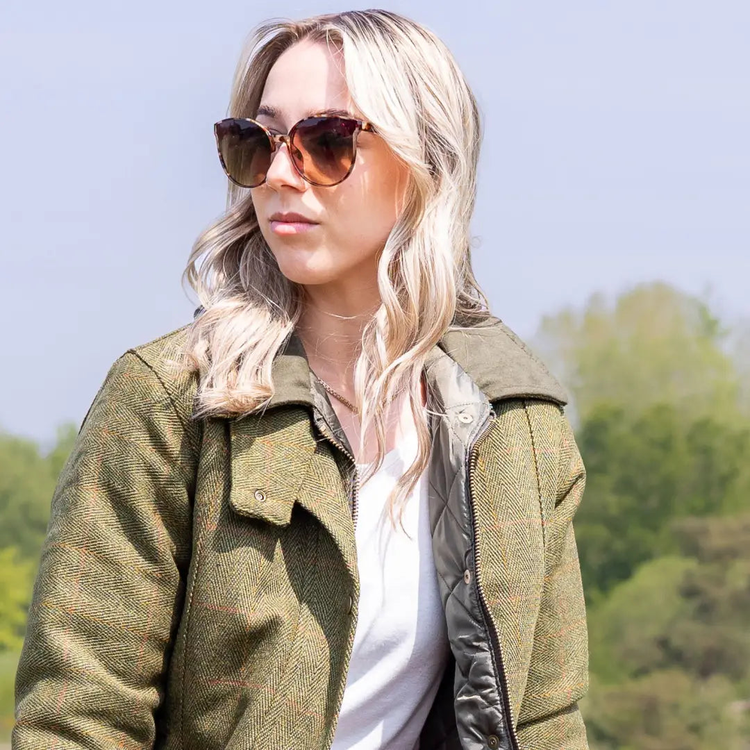 Blonde woman in sunglasses rocking a stylish Ladies Tweed Jacket in olive green