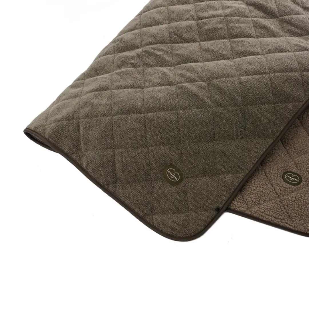 Quilted brown fabric with diamond pattern on Le Chameau Quilted Throw featuring Chameau rubber branding