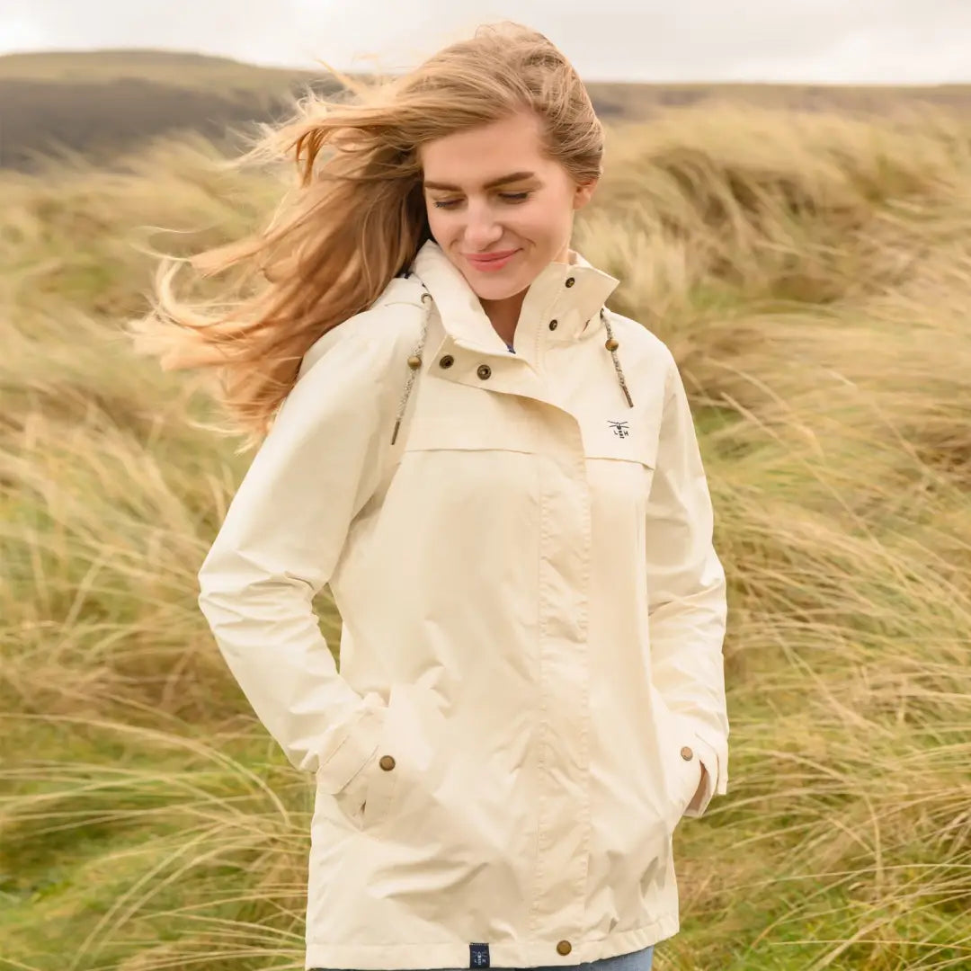 Cream-colored Lighthouse Beachcomber Ladies Waterproof Jacket on windswept blonde woman