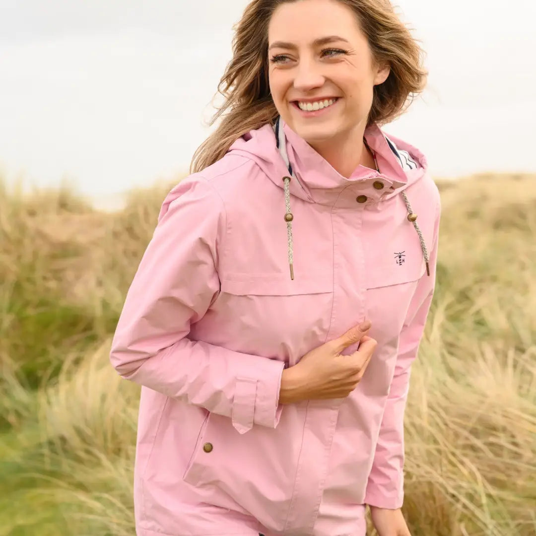 Smiling woman outdoors in Lighthouse Beachcomber Ladies Waterproof Jacket in pink