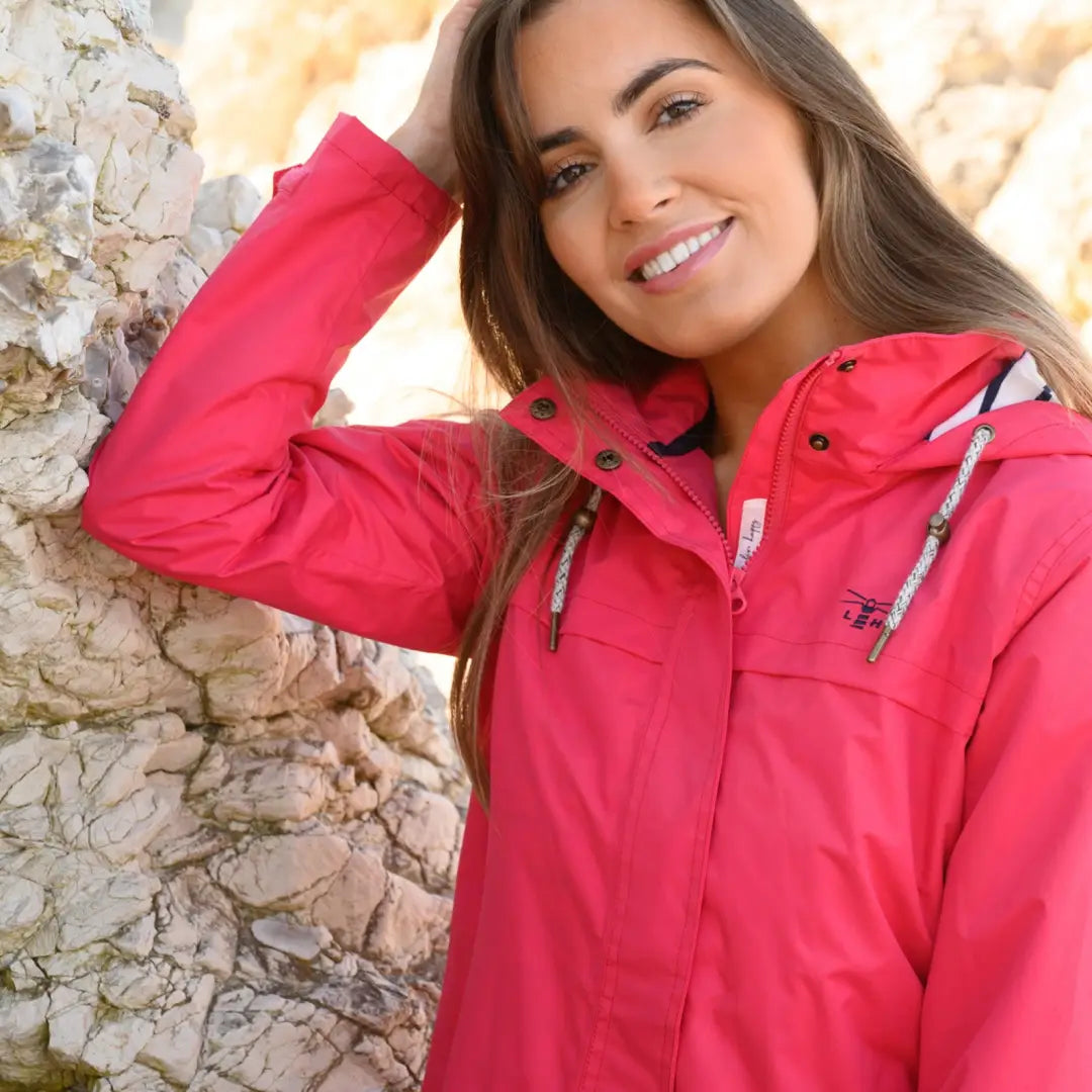 Smiling woman in a bright pink Lighthouse Beachcomber Ladies Waterproof Jacket