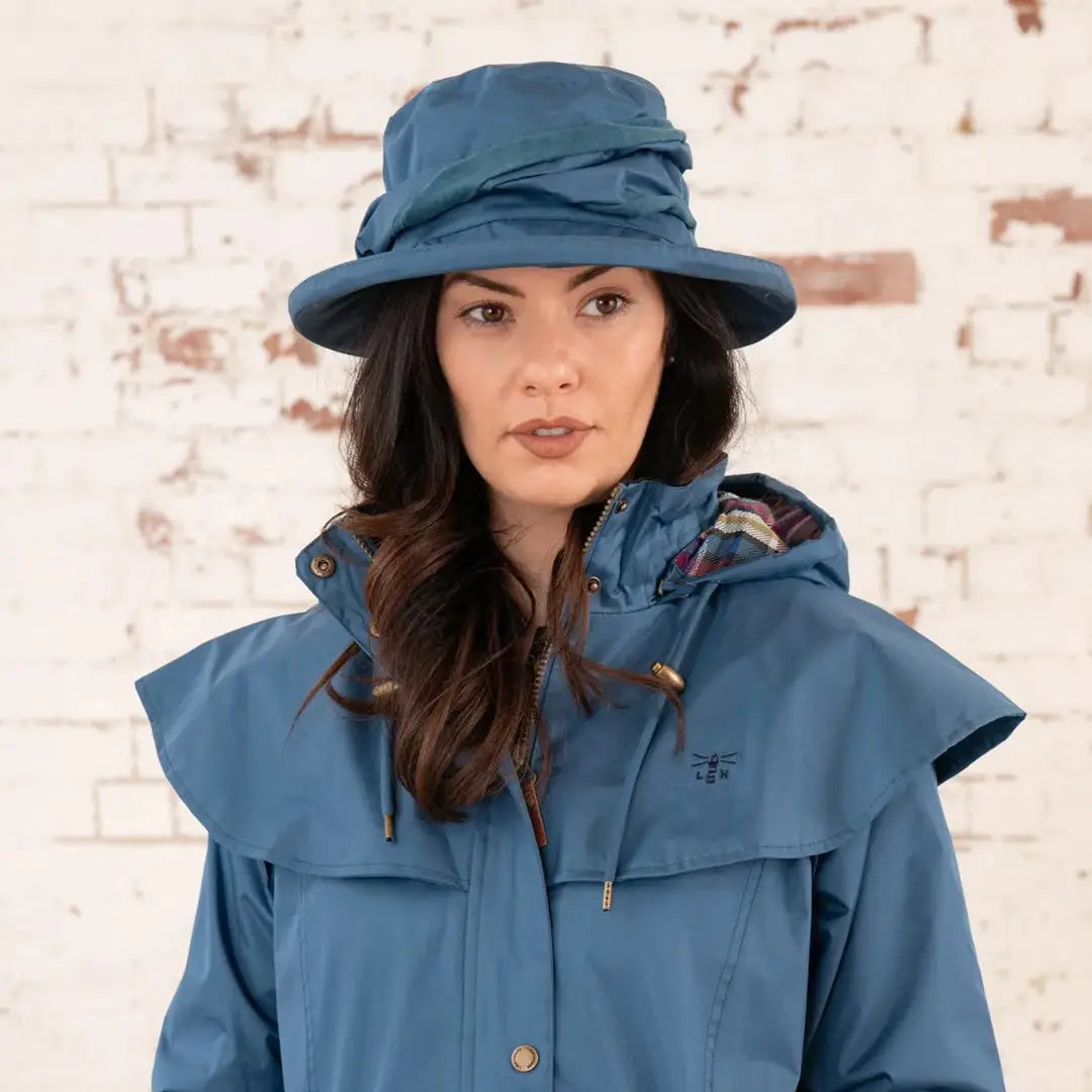 Woman in a blue Lighthouse Canterbury Waterproof Ladies Hat and raincoat