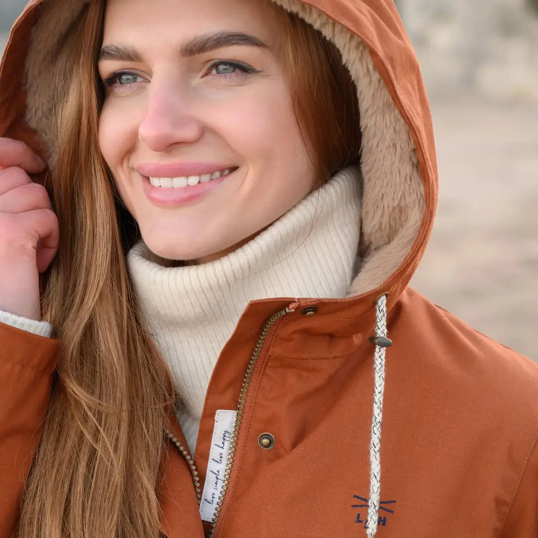 Smiling woman in orange longer length faux fur lined Lighthouse Isobel Coat