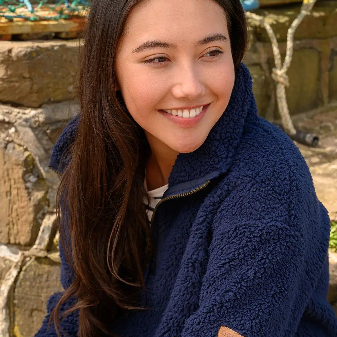 Smiling woman in navy blue funnel-necked half-zip fleece from Lighthouse