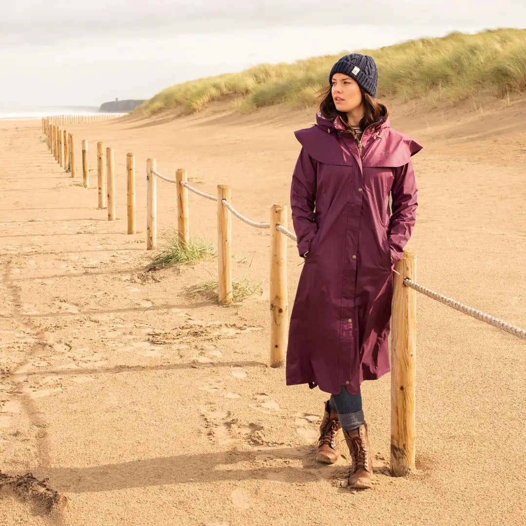 Woman in a long purple Lighthouse Outback Full Length Ladies Waterproof Raincoat on beach