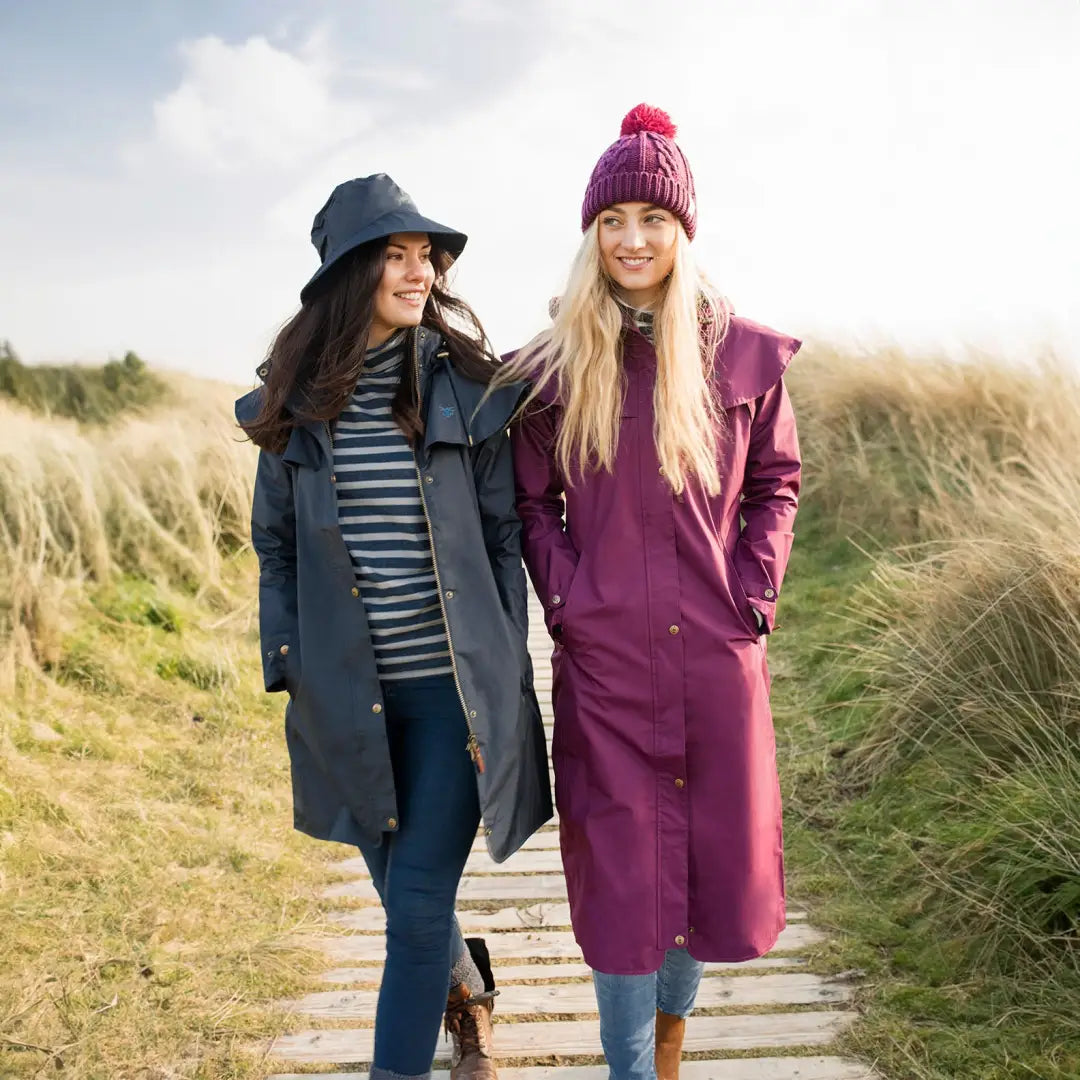 Two women in Lighthouse Outback Length Ladies Waterproof Raincoats walking outdoors