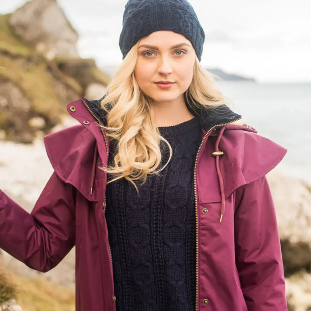 Woman in burgundy jacket and black knit hat models Lighthouse Outback Length Ladies Waterproof