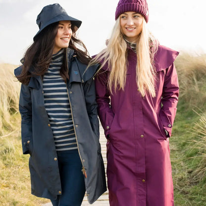 Two women in Lighthouse Outrider 3/4 length ladies waterproof raincoats and hats