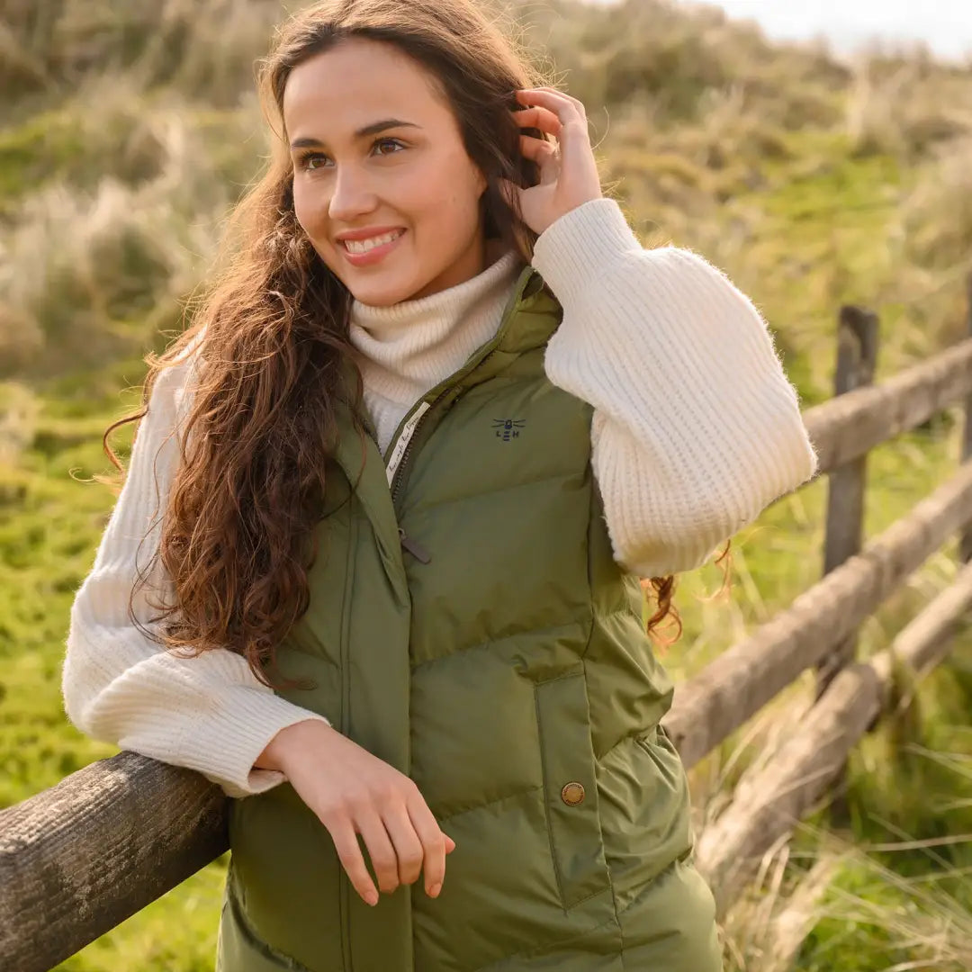 Woman in green puffer vest and white turtleneck modeling Lighthouse Savannah Long Gilet