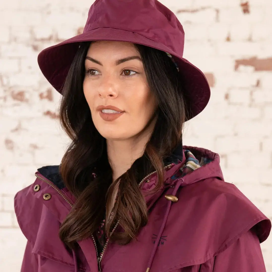 Woman in a burgundy coat and hat from the Lighthouse Storm Waterproof collection