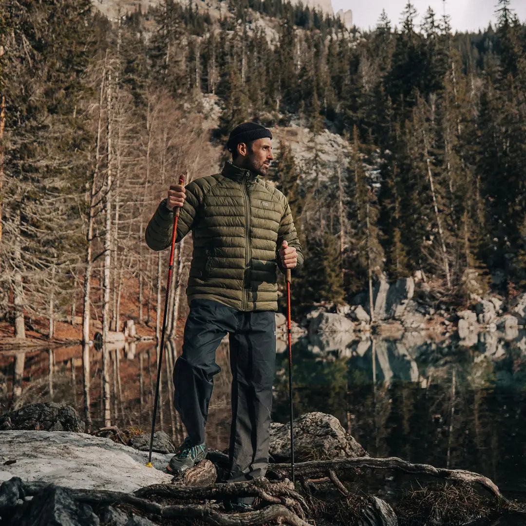 Hiker in Mac In A Sac Mens Synergy Jacket on rocky outcrop enjoying outdoors adventure