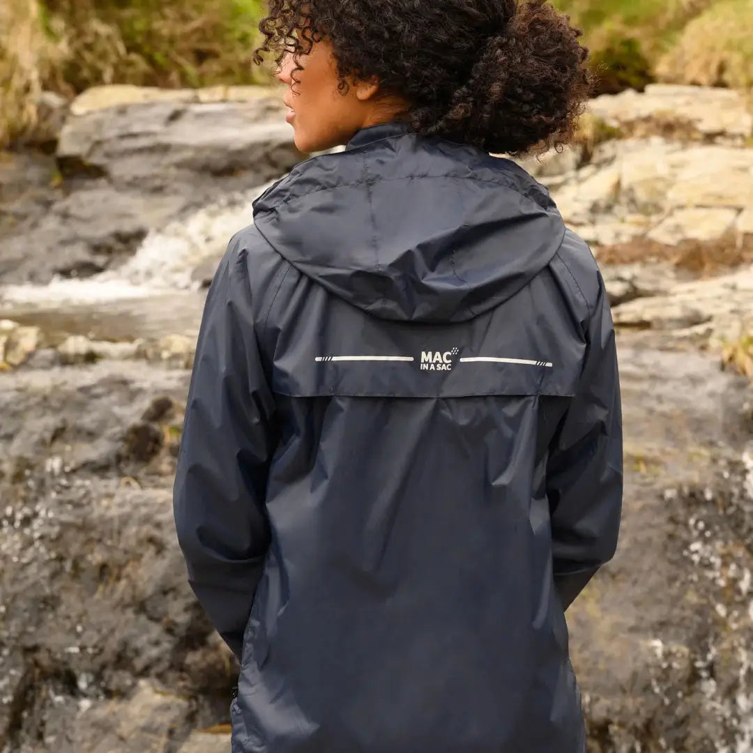 Person with curly hair wearing a Mac in a Sac Origin waterproof jacket with fully taped seams