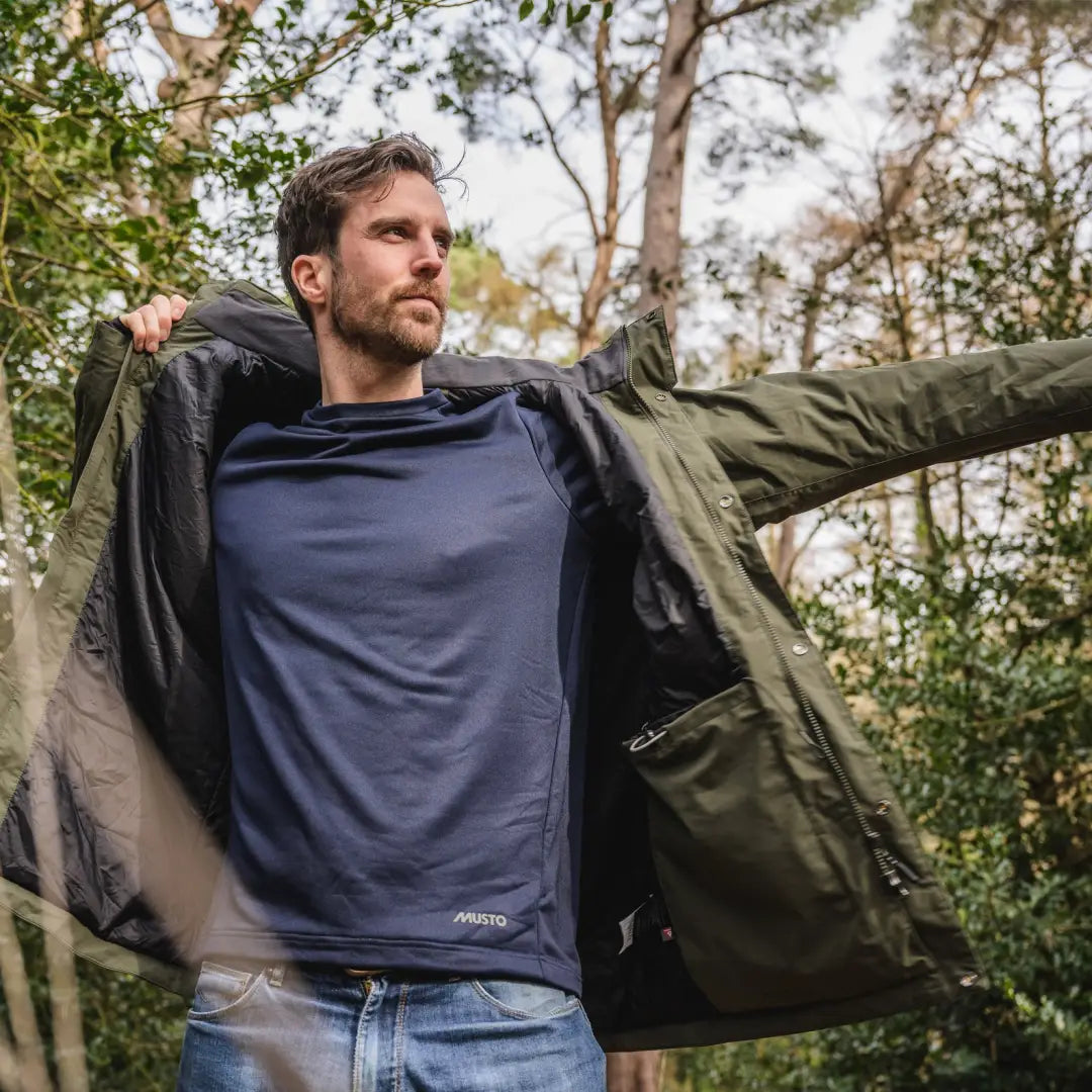 Man in a green Musto Fenland Primaloft® Jacket outdoors, blending style and function