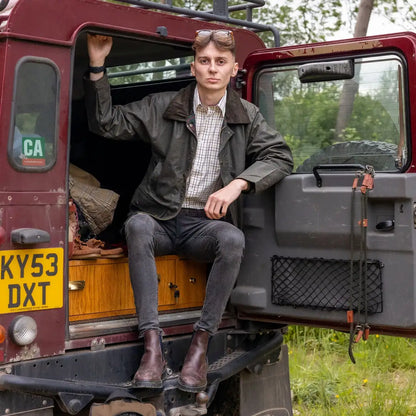 Red vintage Land Rover with open door showcasing Mens Classic Antique Wax Jacket