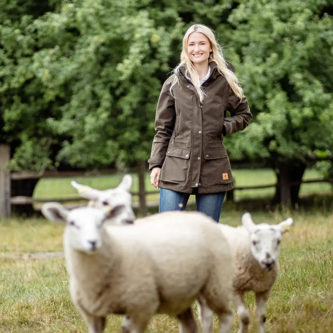 Woman in a brown jacket with sheep in a field, showcasing the New Forest Ladies Country Sport Jacket