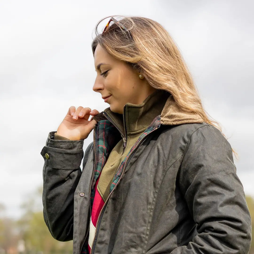 Woman in a dark wax jacket outdoors, perfect for country clothing and hunting adventures