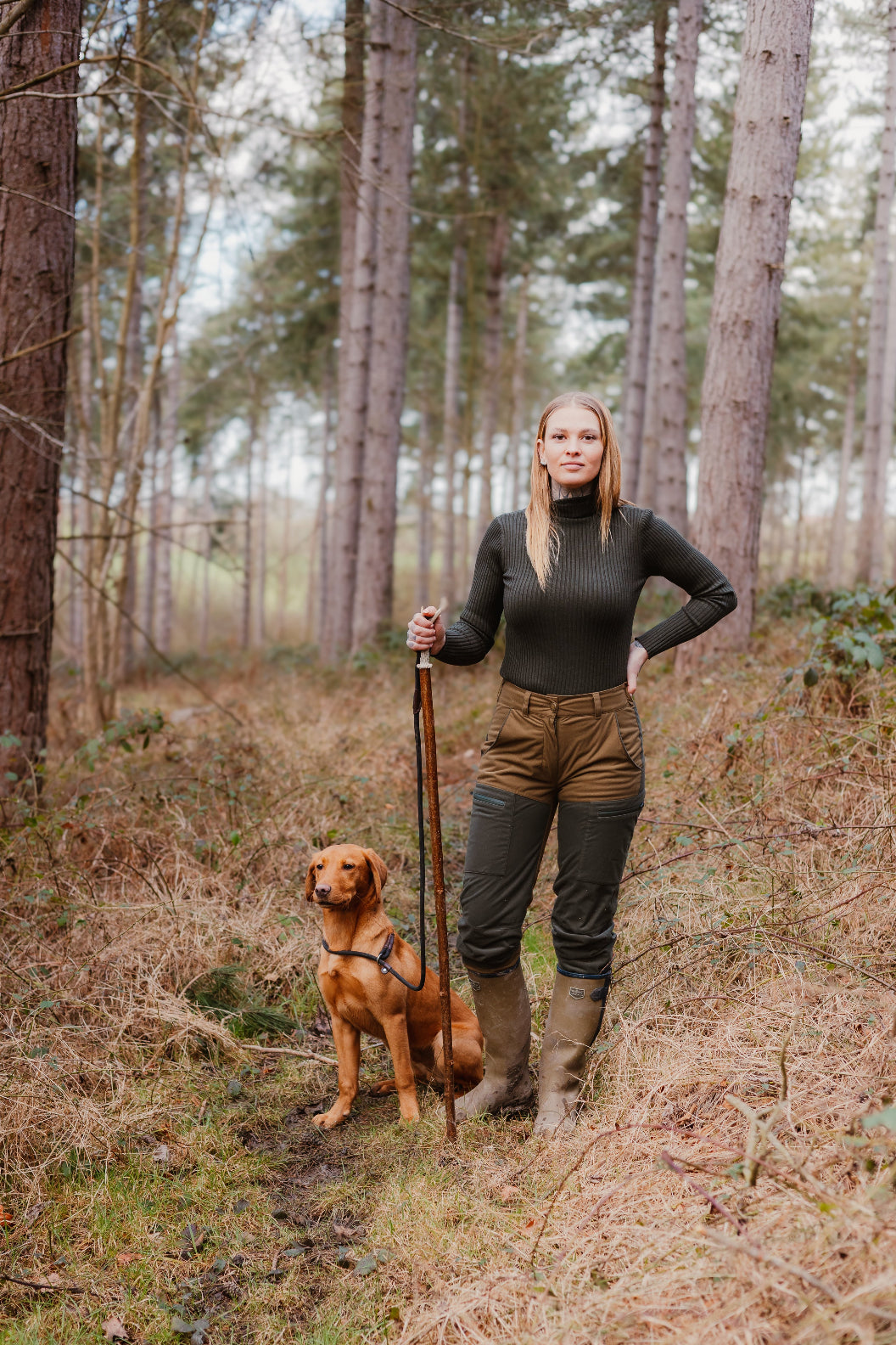 Woman and dog enjoying nature in Forest Nightjar Trousers among trees