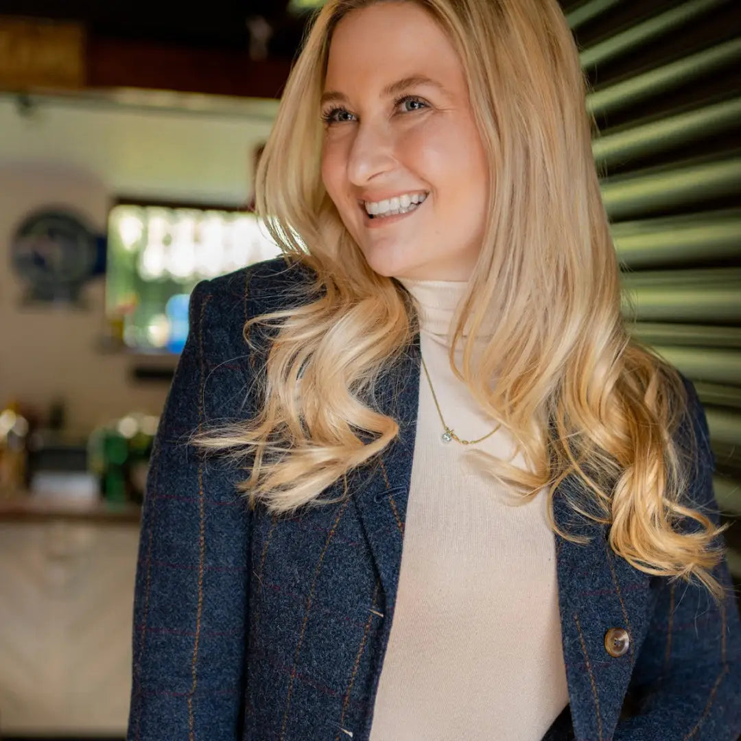 Smiling woman in navy blazer showcases the stylish Forest Lizzie Tweed Coat