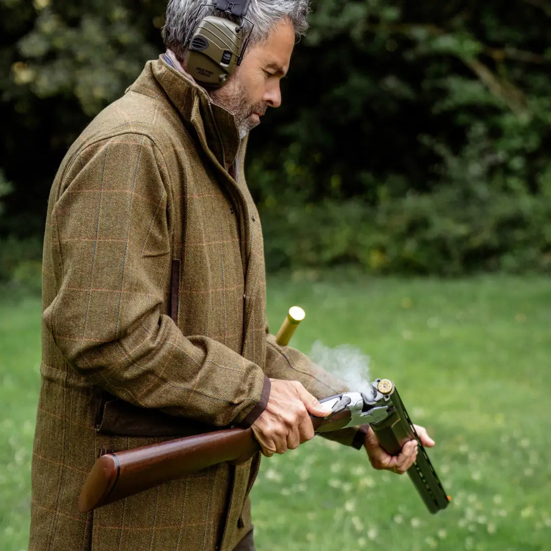 Man in hunting gear reloads shotgun while wearing Maverick Waterproof Tweed Jacket