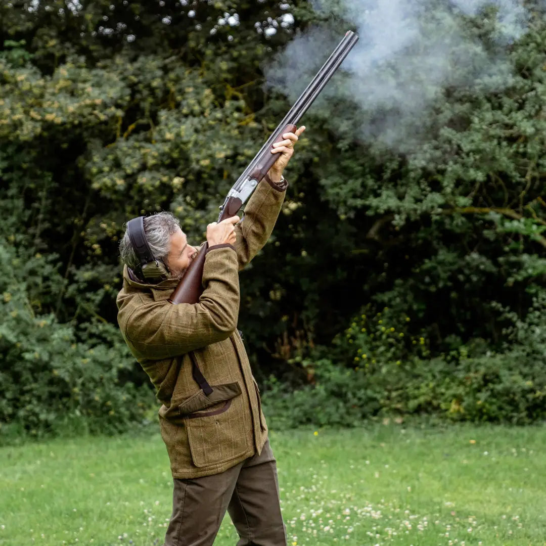 Double-barreled shotgun fired upward, showcasing the New Forest Maverick Waterproof Tweed Jacket