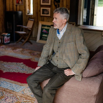 Middle-aged man in a tweed jacket showing off New Forest Moleskin Trousers on a couch