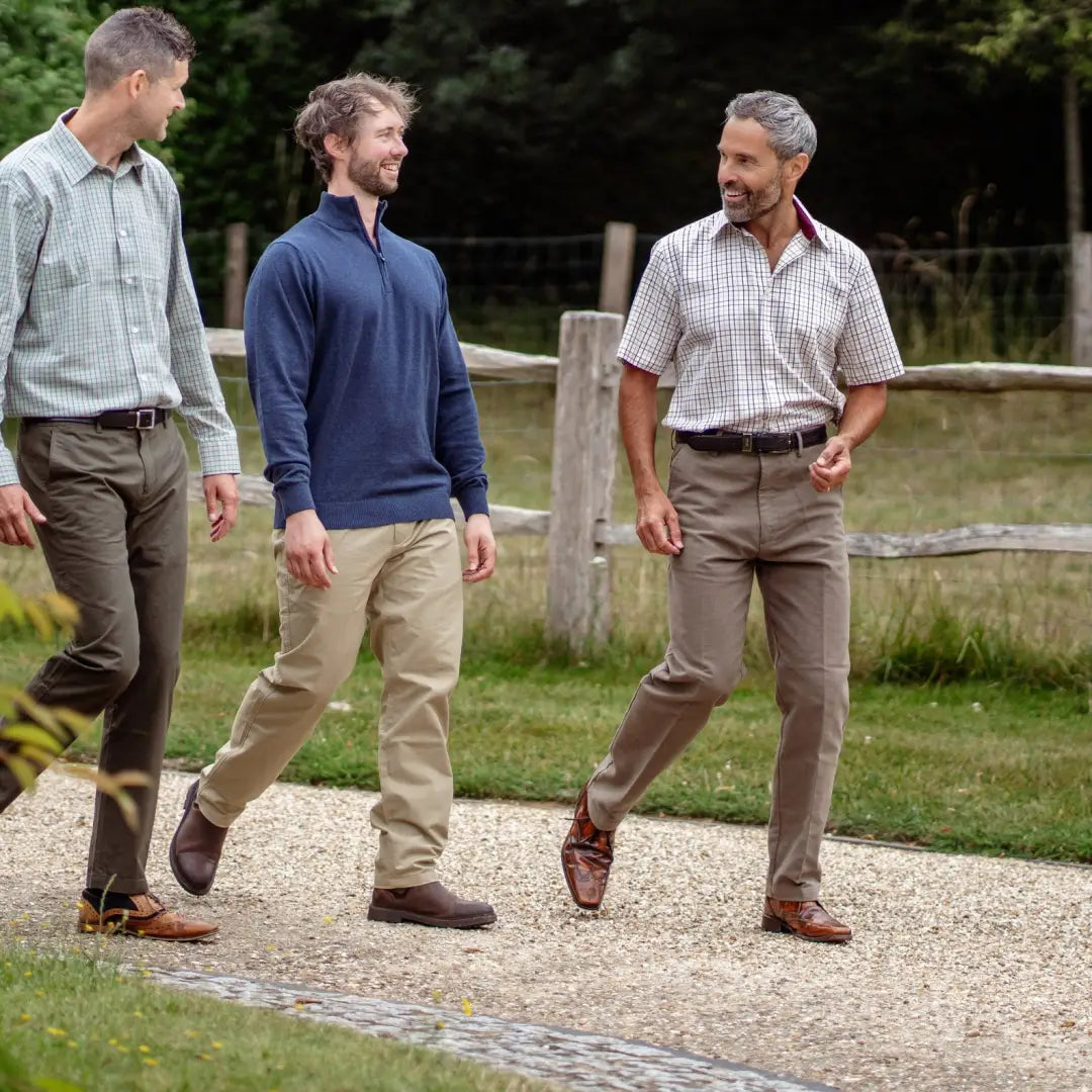 Three men in a New Forest Premium short sleeve shirt stroll down a gravel path