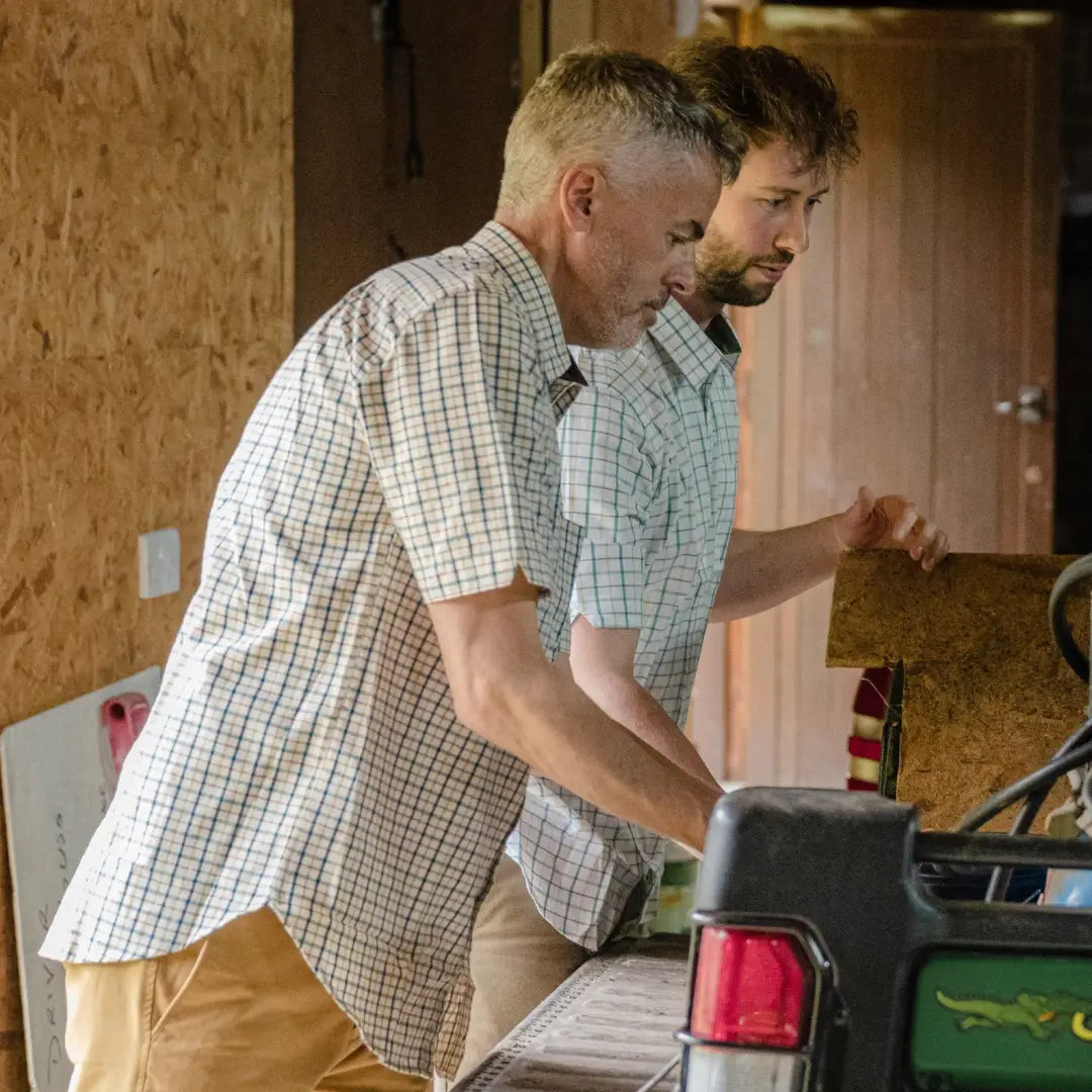 Two men at a kitchen counter wearing New Forest short sleeve country clothing