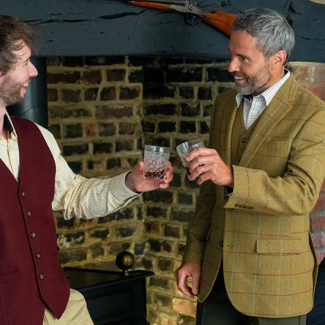 Two men toasting with whiskey in their stylish New Forest wool tweed blazers