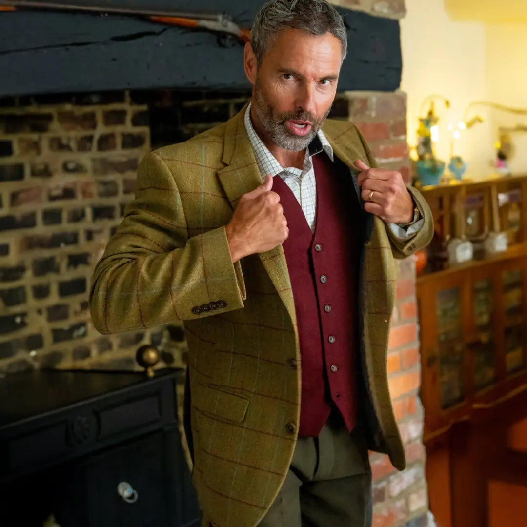 Man in tan wool tweed blazer and burgundy vest looking serious in style