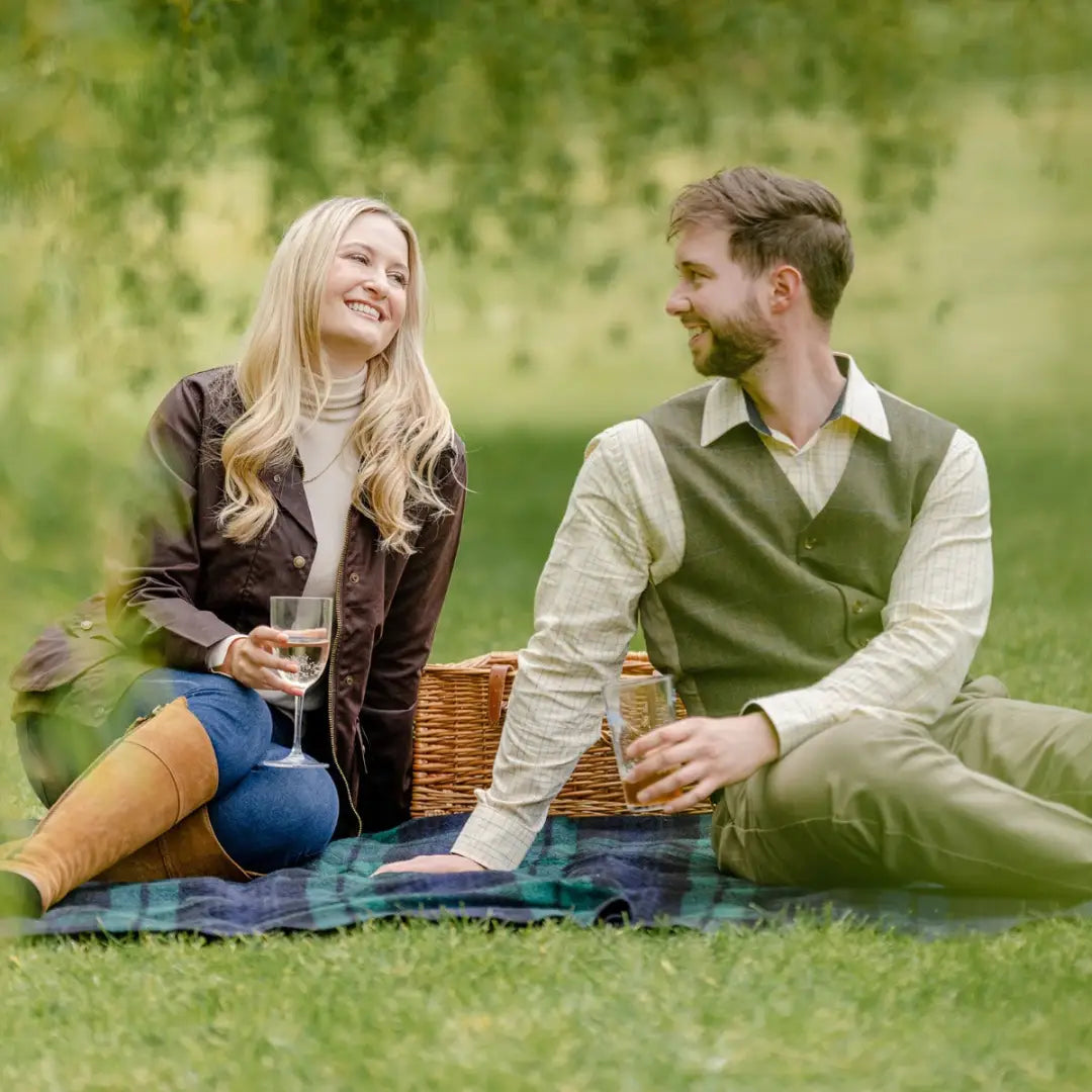 Couple picnicking in a grassy area wearing a stylish wool tweed waistcoat