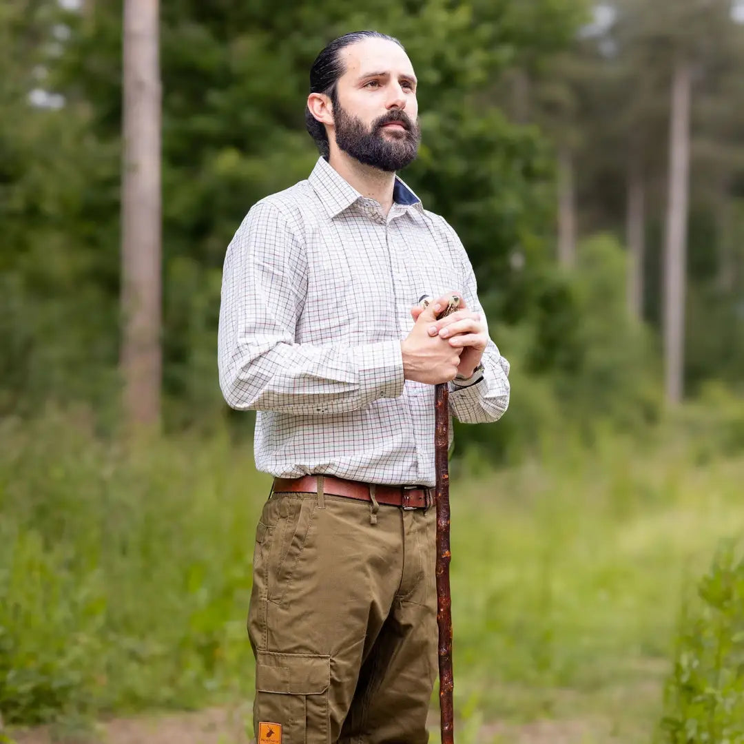 Bearded guy in a checkered Premium Tattersall Shirt and khaki pants with a walking stick