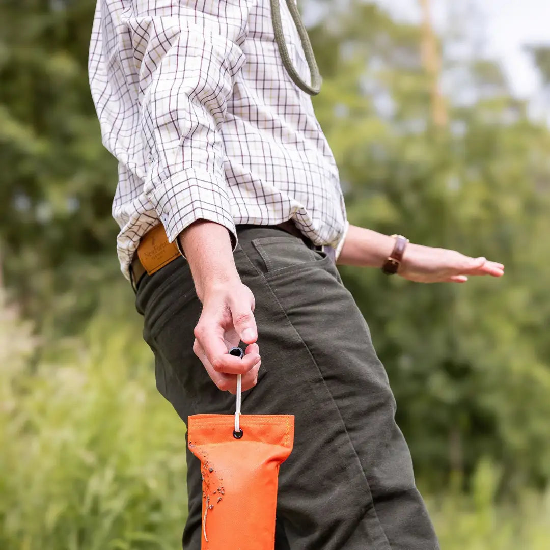 Orange handheld sprayer in hand for New Forest Premium Tattersall Shirt made with cotton fabric