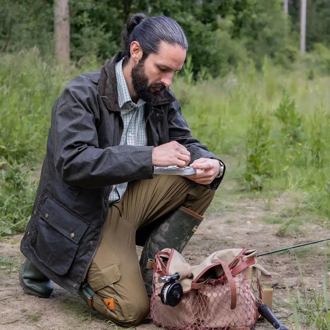 Man with long hair and beard wearing a Forest Premium Tattersall shirt outdoors