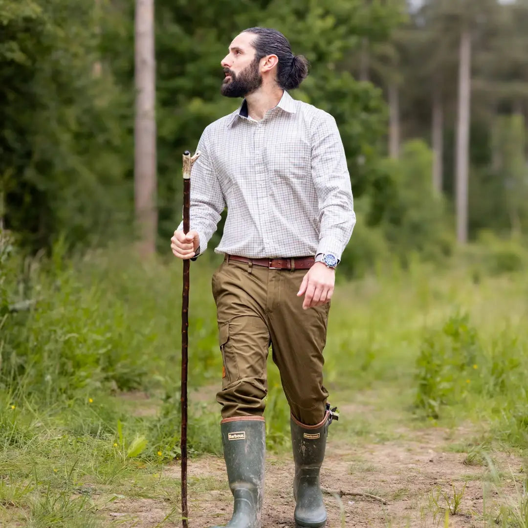 Man with a beard in outdoor gear holding a stick wearing a Premium Tattersall Shirt