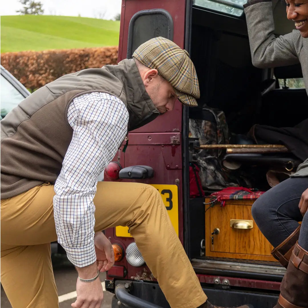 Man in flat cap and vest entering vehicle, showcasing New Forest Premium Tattersall Shirt