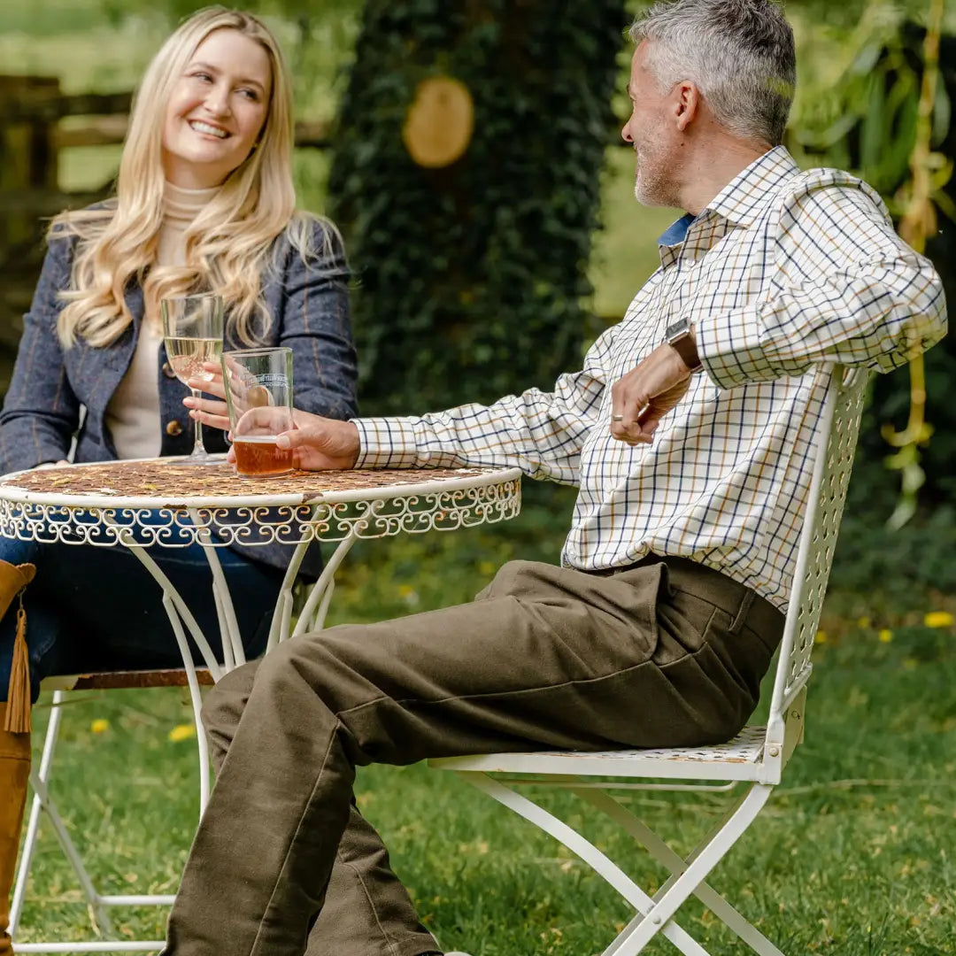 Two people enjoying drinks outdoors while wearing a stylish Forest Premium Tattersall Shirt