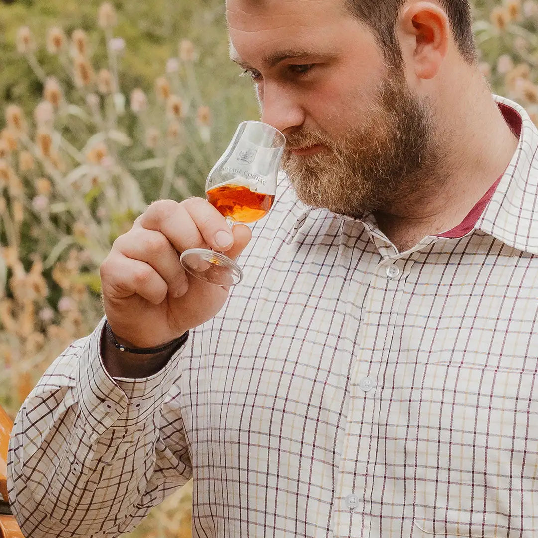 Man with a beard enjoying a drink wearing a New Forest Premium Tattersall Shirt