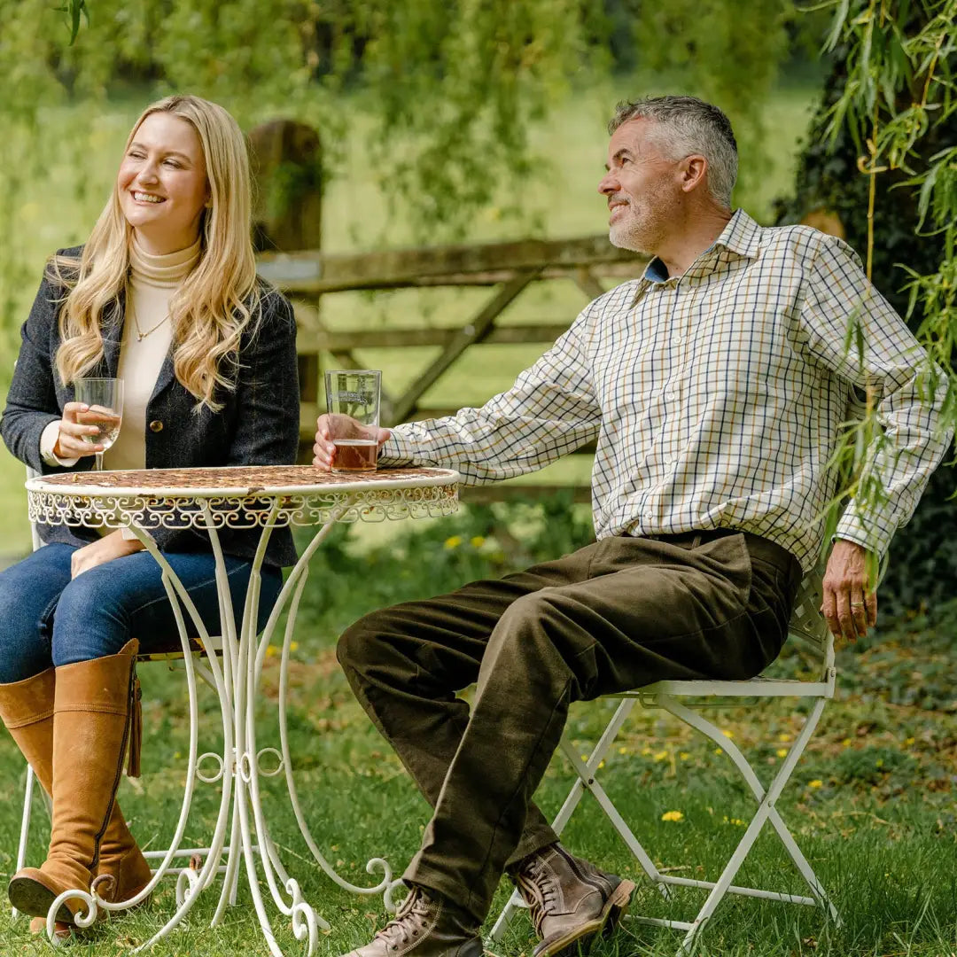 Two friends chilling at an outdoor table in a stylish New Forest Premium Tattersall Shirt