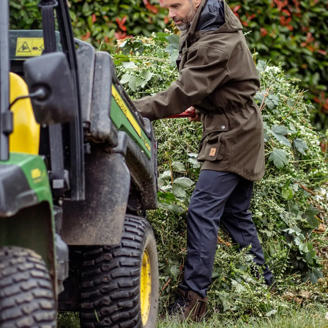 Person loading leafy greens into a tractor while wearing Forest Trail Trousers