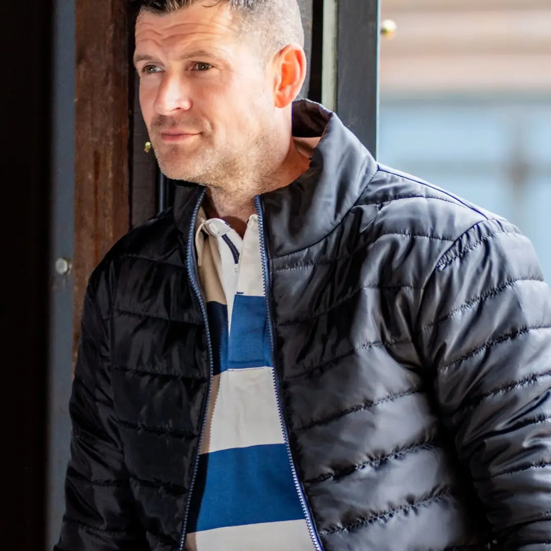 Middle-aged man in a black puffer jacket and striped shirt showcasing the Forest Trek Jacket