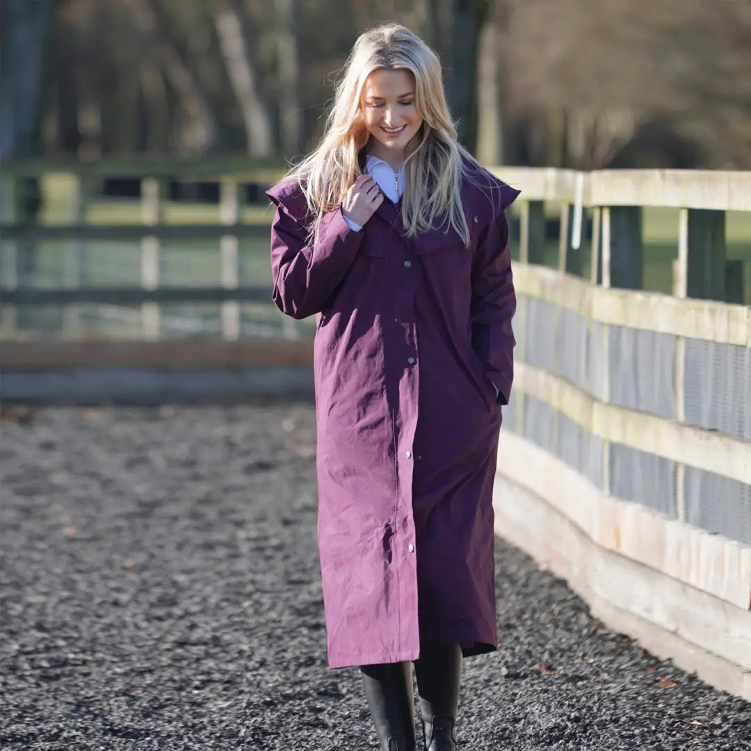 Woman with blonde hair in a long purple coat for uncompromising wet weather