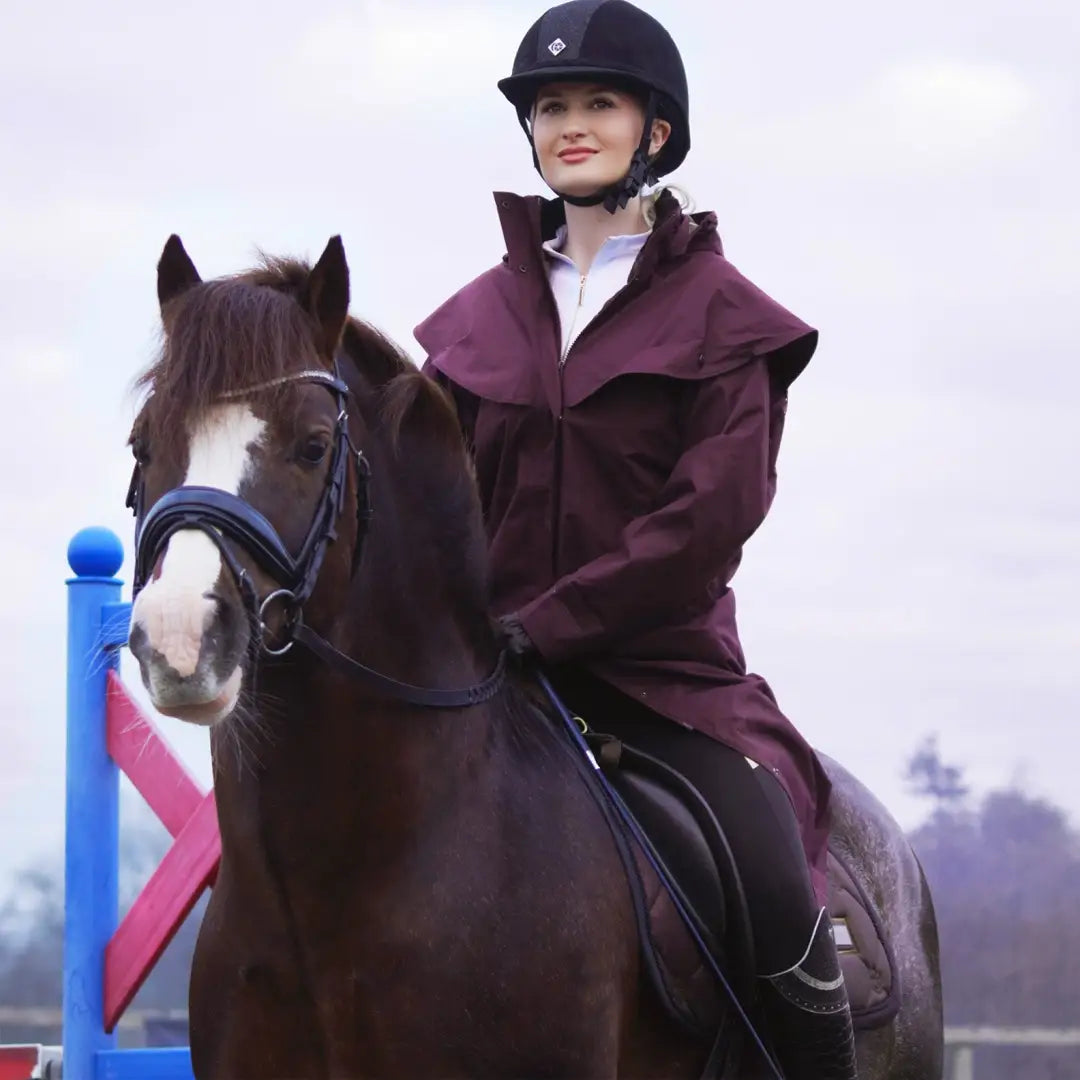 Horse and rider in equestrian gear showcasing the New Forest Victoria waterproof coat for uncompromising wet weather